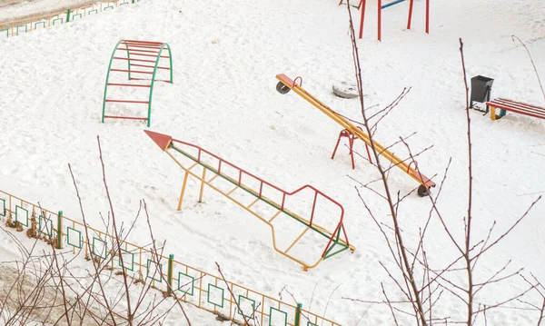 Şehir parkında soğuk bir kış gününde çocuk salıncakları ve slaytlar boşaltılıyor..