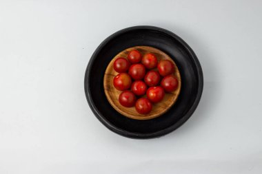 Tahta tabakta Lycopersicon ve beyaz arkaplanda el yapımı kil