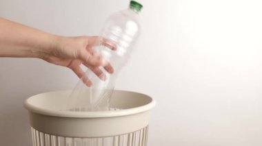 Boş bir plastik şişe çöp sahasına atılıyor. Çöp öğütme ve geri dönüşüm için.