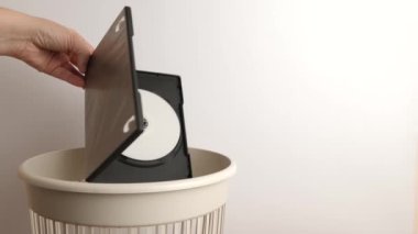 The CD in the plastic box is thrown away for recycling and disposal