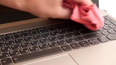 Adam dizüstü bilgisayarını fırçayla temizliyor. PC bakım kavramı