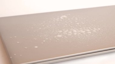 Adam dizüstü bilgisayarın kapağını deterjanla temizliyor. PC bakım kavramı