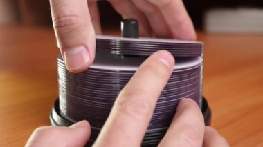 The man folds and counts the disks.