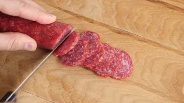 Tahtadaki bıçakla sosisi kes. Mutfakta çalış..