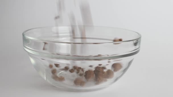 Granola Derramado Uma Tigela Transparente Fundo Branco Alimentos Saudáveis — Vídeo de Stock