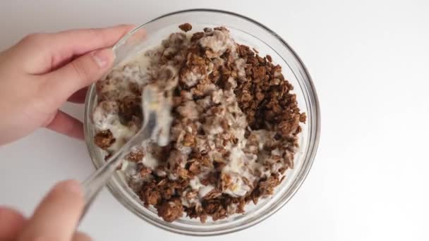 Campuran Granola Dengan Yogurt Dalam Mangkuk Transparan Pada Latar Belakang — Stok Video