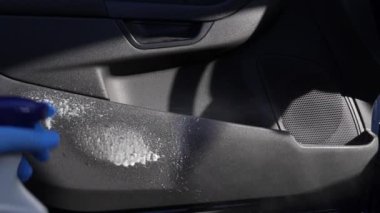 Bir adam arabayı deterjan ve bezle temizliyor. Araba temizleme konsepti.