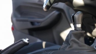 Adam arabaya biner, emniyet kemerini bağlar ve el frenini çeker. Güvenli sürüş konsepti.