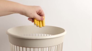 Adam geri dönüşüm ve geri dönüşüm için pil ve pilleri çöpe atıyor.