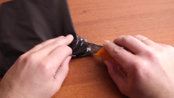 Man Opens Black Plastic Envelope Stationery Knife — Stockvideo