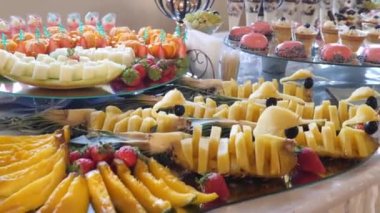 Kek ve meyveli büfe. Üzüm, ananas, portakal, mandalina ve daha fazlası. Açık büfe masa tasarımı.
