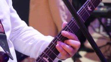 Guitarist plays guitar in an orchestra at a concert.