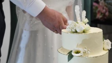 Gelin ve damat bıçağı birlikte alın ve düğün pastasını kesin..