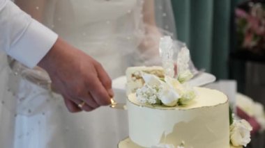 Gelin ve damat bir parça düğün pastasını tabağa koydular..