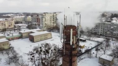 Emissions into the atmosphere come from a large industrial pipe. Air pollution concept. Shooting from the air.