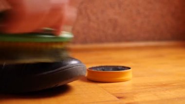 A man cleans leather shoes with a paste and a brush. Shoe care.