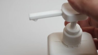 Adam beyaz plastik şişeden beyaz krema sıkıyor..