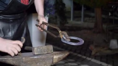 Demirci profesyonel olarak sıcak metalden bir at nalı yapar. Nalbantlık mesleği. Yapı.