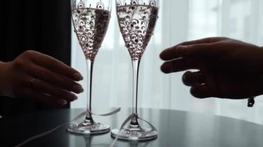 Bir adam ve bir kadın kadehlerini şampanya ve köpüklü şarapla kaldırıyorlar..