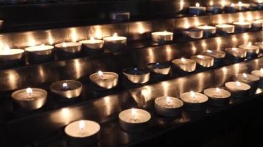 Burning candles on a multi-tiered stand in the church.