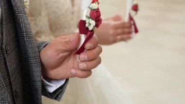 Gelin ve damat bir kilise düğünü sırasında ellerinde mum tutarlar. Dini törenler ve gelenekler.