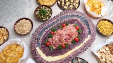 Açık büfe masasının dekorasyonu et tabakları, fındıklar, cipsler.