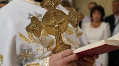 Rahip elinde bir İncil ve bir haç tutarak vaaz veriyor..