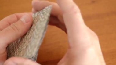 Adam oyuna başlamak için bir deste kağıt karıştırıyor. Tahta oyunu konsepti.