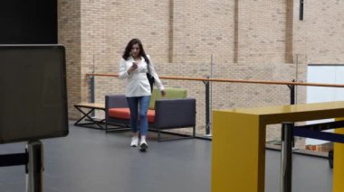 Güzel kız iş merkezinin koridorunda yürüyor..