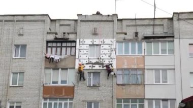 İşçiler tipik bir Sovyet evini yalıtıyorlar. Enerji tasarrufu kavramı.