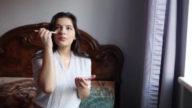 Beautiful girl doing makeup at home