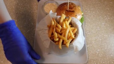 Yemek servisi. Hamburger, kızarmış patates ve sos..