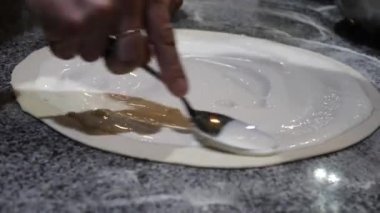 Pizza pişiriyorum. Pizza tabanına peynir sürüyorum.