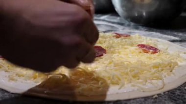 Cooking pizza. Applying salami to the pizza base