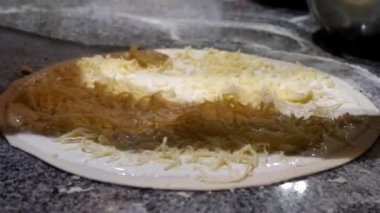 Pizza pişiriyorum. Pizza tabanına peynir sürüyorum.