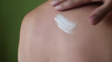 The man applies a cream to care for and protect the skin. Body skin care. Protection against excessive sunburn and skin irritation.