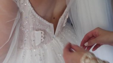 Bir arkadaş gelinin elbisenin kilidini açmasına yardım eder..