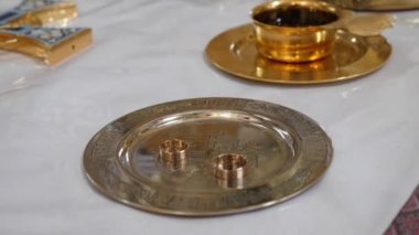 Golden wine bowl and wedding rings for a church wedding ceremony. Items of church worship and national rites.