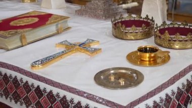 Şarap, alyans, haç, taç ve kilise töreni için İncil içeren altın kupa. Kiliseye tapınma ve milli ayinler..