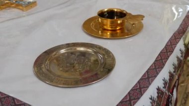 Golden wine bowl and wedding rings for a church wedding ceremony. Items of church worship and national rites.