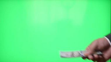 Transfer and transfer of money from hand to hand on a green background.