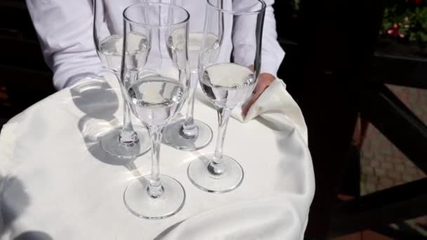 Waiter Holds Tray Four Glasses Filled White Sparkling Wine — стоковое видео