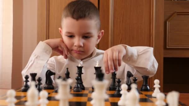 Little Boy Ponders Next Chess Move — стоковое видео