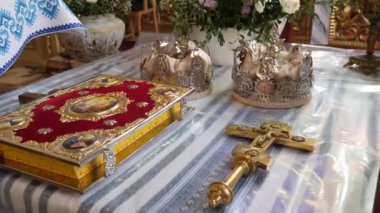 Church wedding ceremony. The Gospel, the crown and the cross stand on the throne.