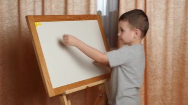 Evde öğreniyorum. Çocuk manyetik harflerle alfabeyi öğreniyor..