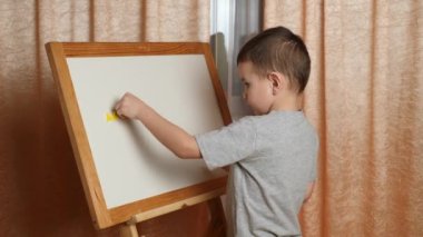 Evde öğreniyorum. Çocuk manyetik harflerle alfabeyi öğreniyor..
