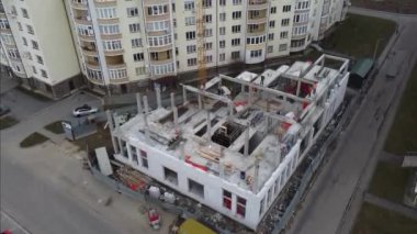 İnşaat alanının havadan görüntüsü üzerinde çalış. İşçiler ve inşaat ekipmanları bu süreçte.