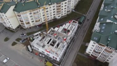 İnşaat alanının havadan görüntüsü üzerinde çalış. İşçiler ve inşaat ekipmanları bu süreçte.