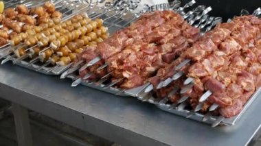 There are a lot of meat and vegetable skewers on the counter. Street food concept.