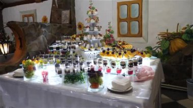 Meyveler, tatlılar ve kekler ile şenlikli tatlı masa. Tatlı bir masanın ahenkli servisi..